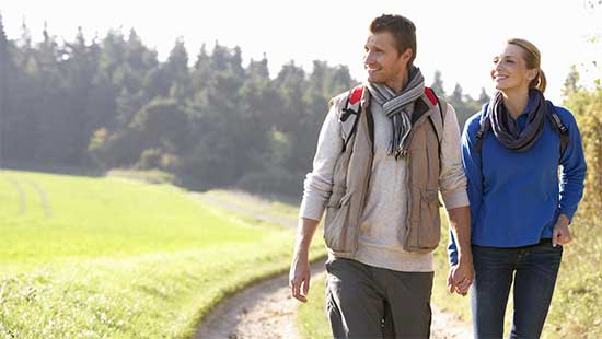 Young couple walking through a park holding hands