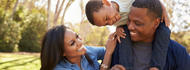 Parents carrying child on shoulders