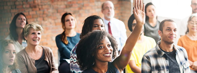 Woman raising hand in group setting 