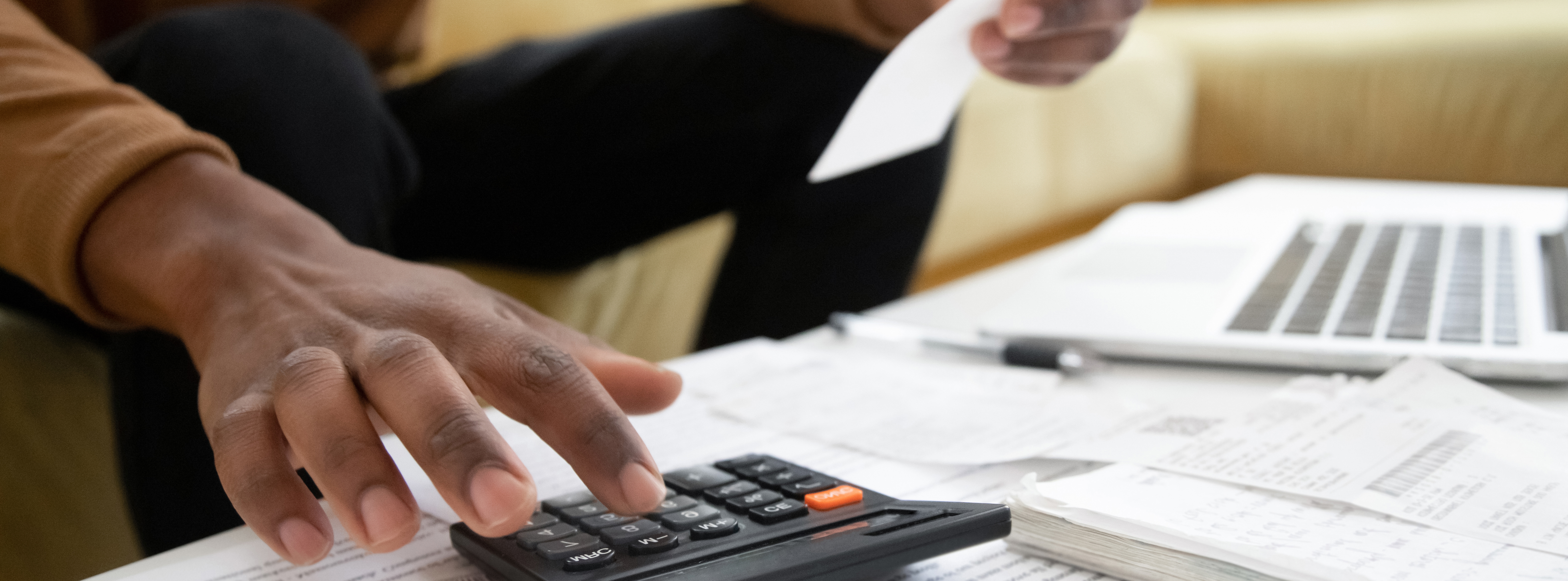 Man calculating taxes on a couch