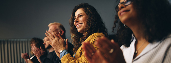 People clapping their hands at an event