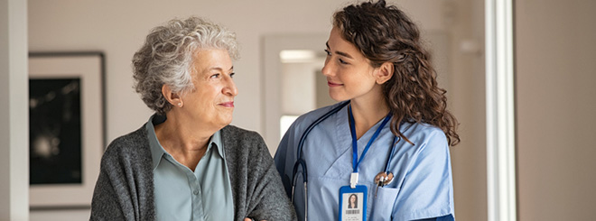 A nurse and senior woman walking at the hospital 