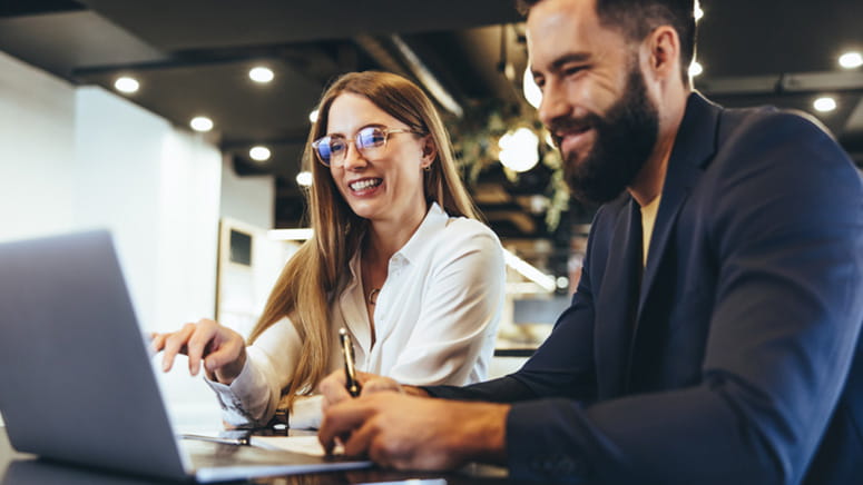 Cheerful business people working on a computer