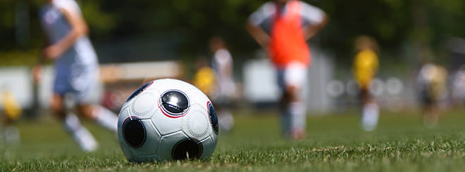 Close up of a soccer ball with players in the background