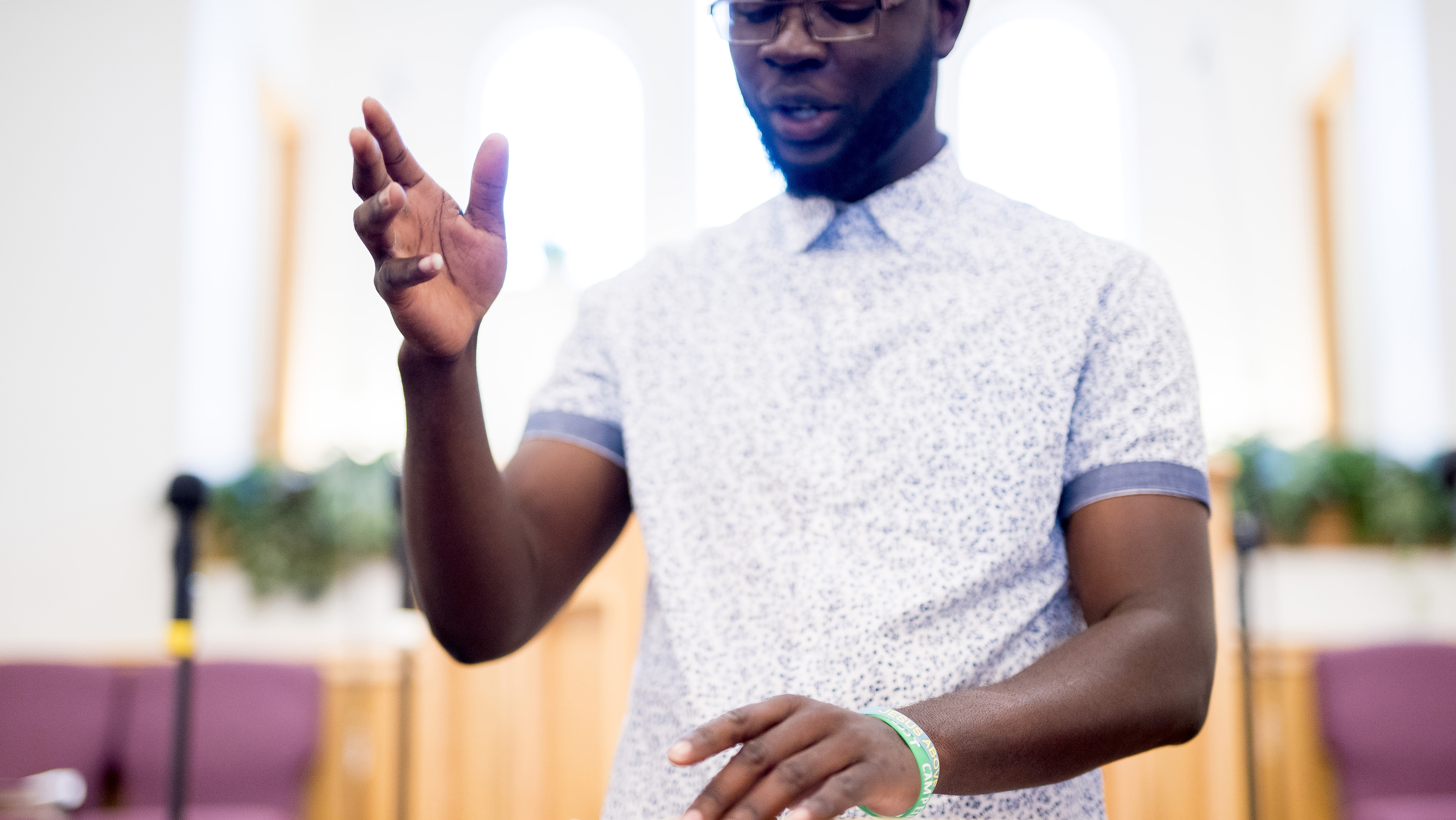 African American man reads from Bible at church lectern