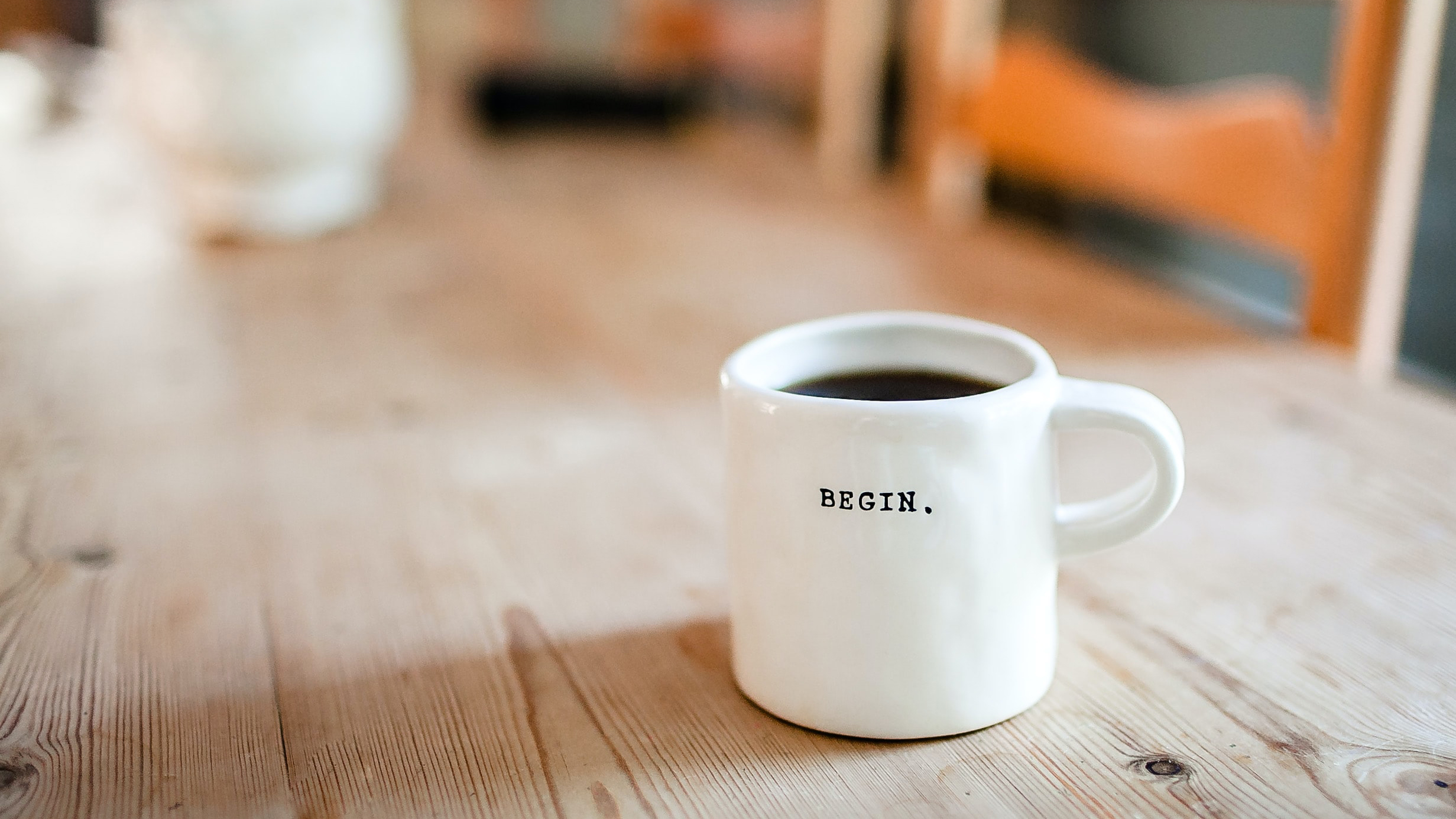 Mug that says breathe stis on a wooden kitchen table