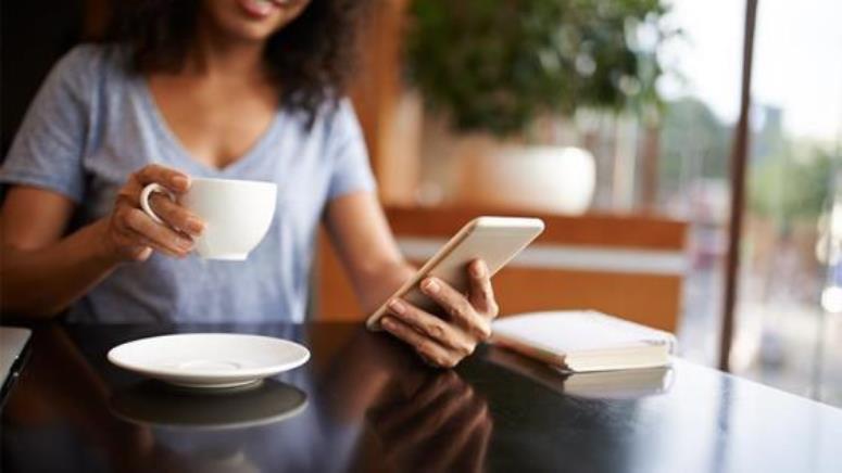 Close up of woman using phone in a coffee shop