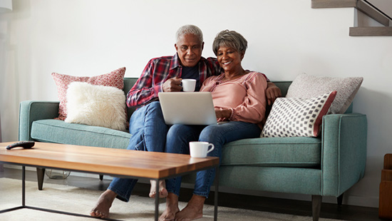 Couple sitting on couch drinking coffee