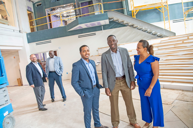 Kevin Gil, Randy Nyce, Bryant Keel, Leonard Dow and Natalie Martinez stand smiling and laughing inside for photo construction for new Everence building in Philly