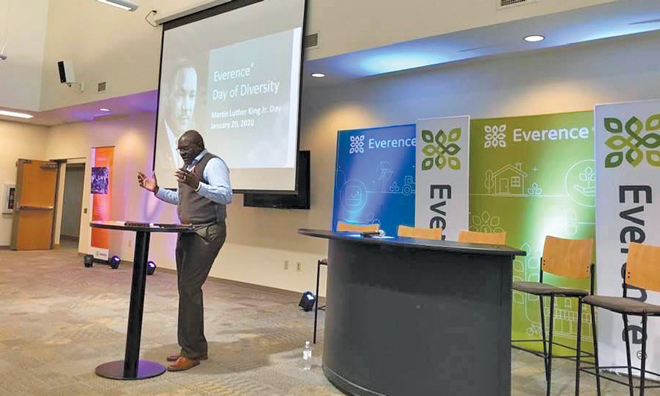 Leonard Dow of Everence addresses fellow employees on Martin Luther King Jr. Day with Everence signage in background