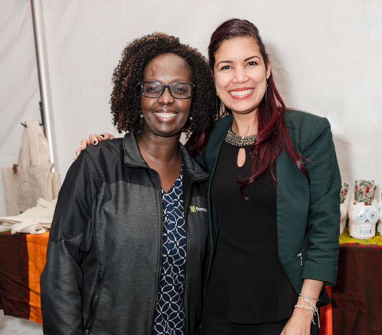 Two women stand posing for a photo. 