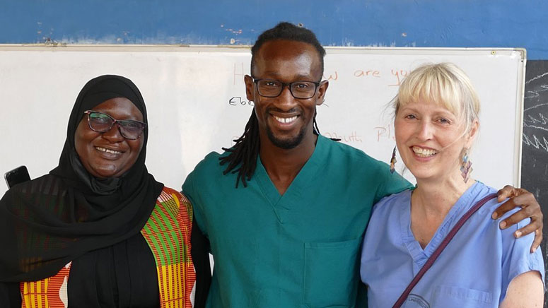 A photo of three people from their chest up. They are posing for the photo