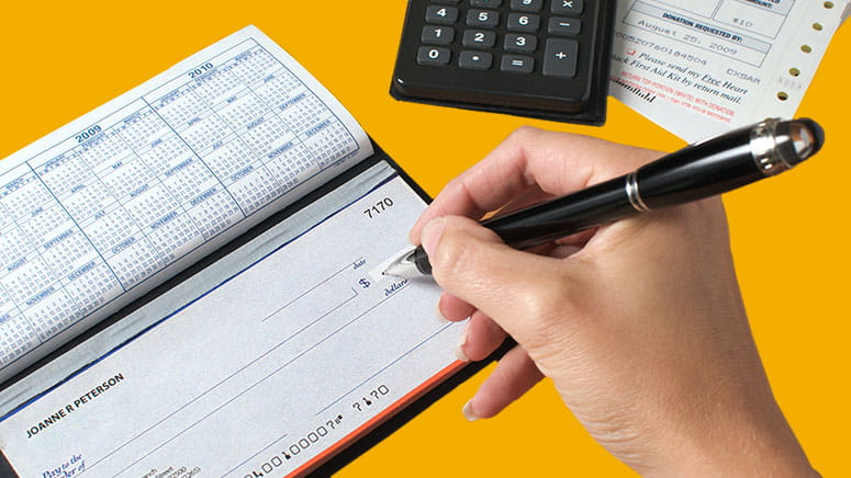 Person filling out a checkbook