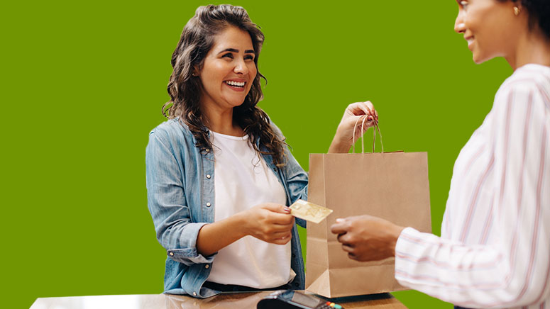 Woman handing credit card and shopping bag over to customer