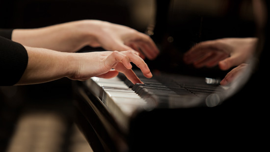 Close up of hands playing piano