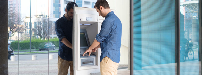 Man standing at an ATM