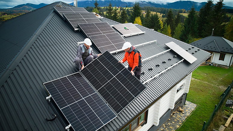 Workers installing solar panels on a roof