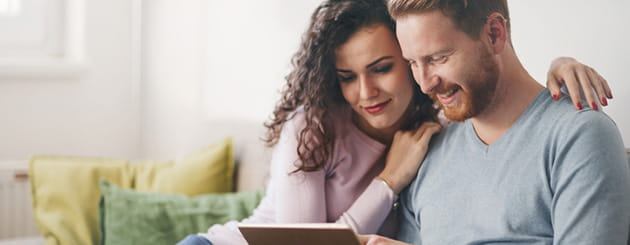 man and woman looking at ipad