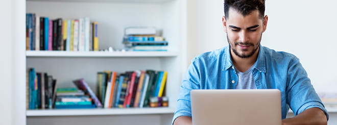 Man using laptop to video bank