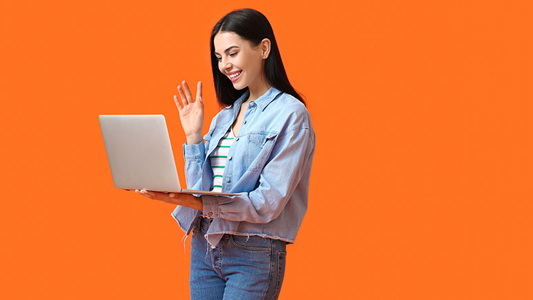 Woman waving at laptop screen