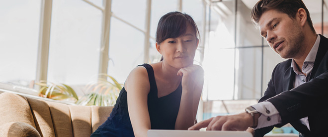 Woman looking at computer with man