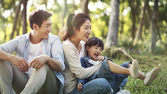 Man, woman and child play outside in the forest