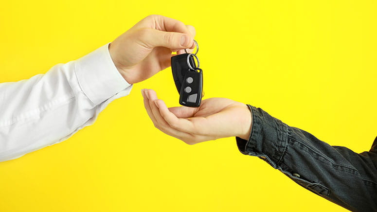 Two people passing over car keys