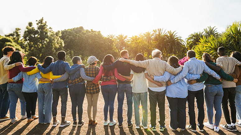 Group of people with their arms around each other