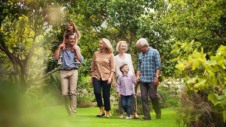 Multi-generational family walking through a field