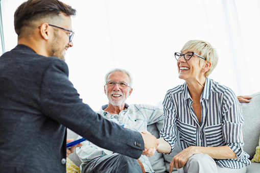 Older couple shaking hand with advisor