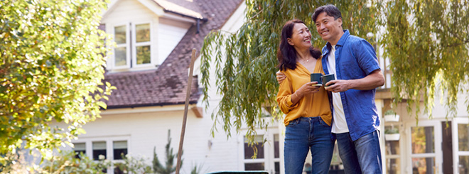 Couple smiling outside of their house