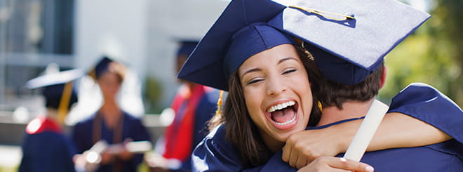 Women embracing in graduation attire 