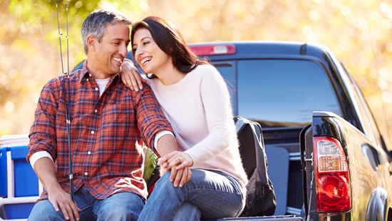 Couple sat on the back of a truck 