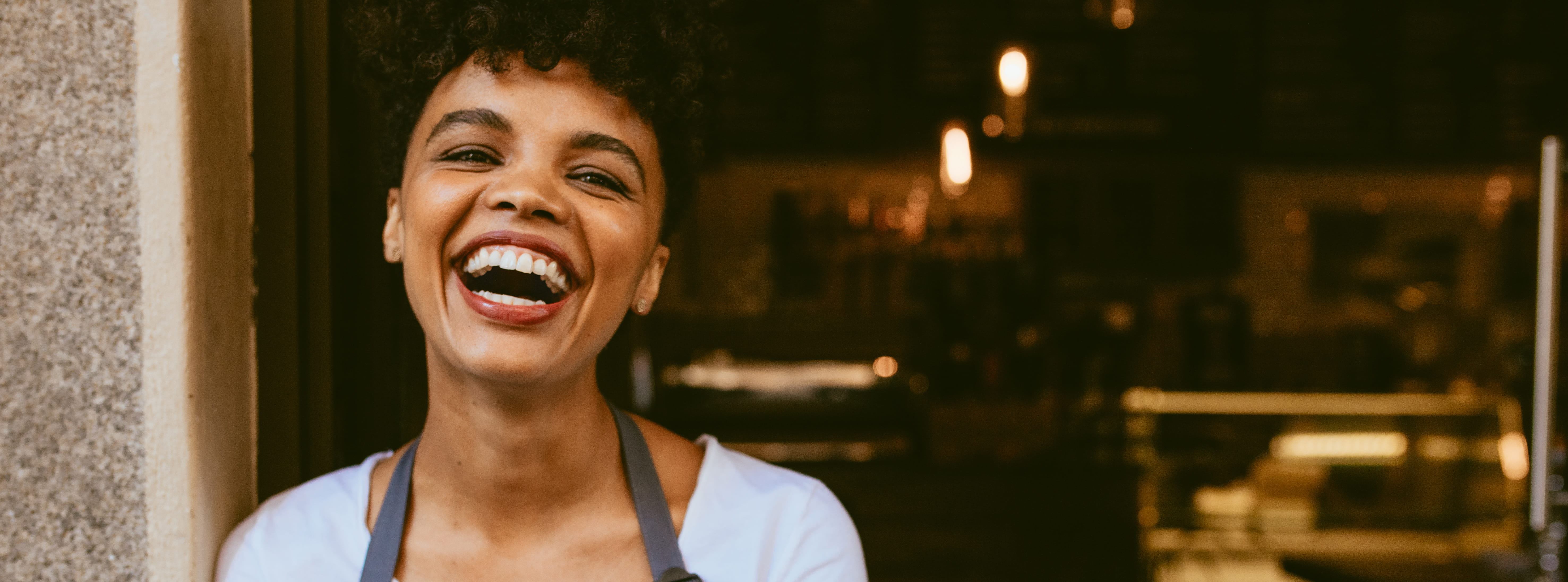 Young African American business owner smiling in front of her shop