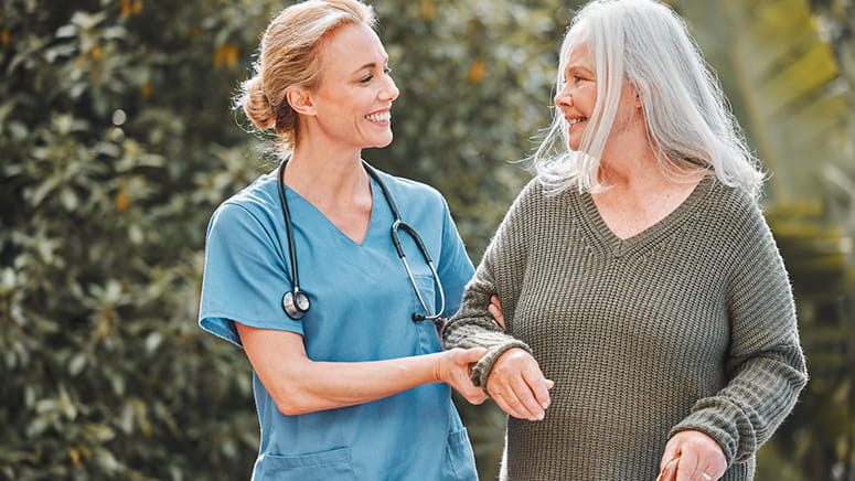 Nurse helping patient walk at nursing home