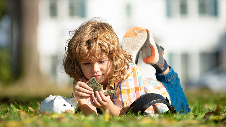 Child counting money for piggy bank