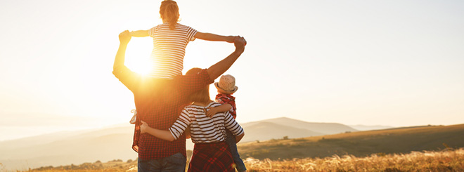 family looking into field and sunset