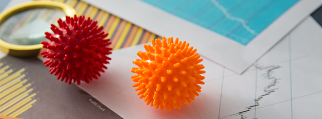 Two rubber stress balls on desk with paper financial charts