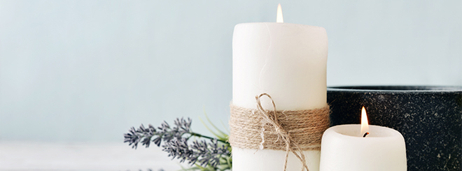 Two lit candles and lavender sprig